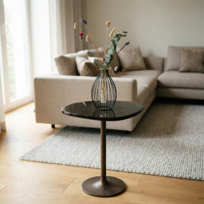 Moderne woonkamer met ronde marmeren bijzettafel, zwarte metalen vaas met droogbloemen en beige hoekbank