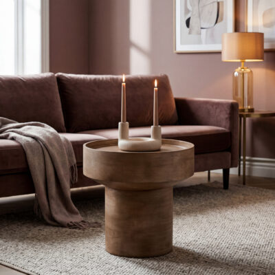 Ronde houten bijzettafel met opstaande rand en beige kandelaar voor een bruine bank in een warme woonkamer