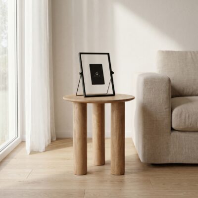 Lichte woonkamer met ronde houten bijzettafel, zwart fotolijstje en beige bank