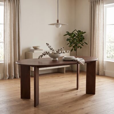 Donkerbruine ovale eettafel met vier brede poten in een warme moderne eetkamer met vaas, servies en hanglamp