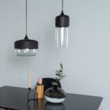 Zwarte hanglampen boven een tafel met glazen kappen